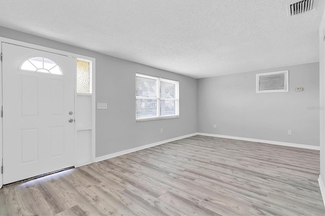 entrance foyer with a textured ceiling and light wood-type flooring