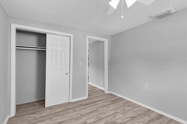 unfurnished bedroom with light wood-type flooring, ceiling fan, and a textured ceiling