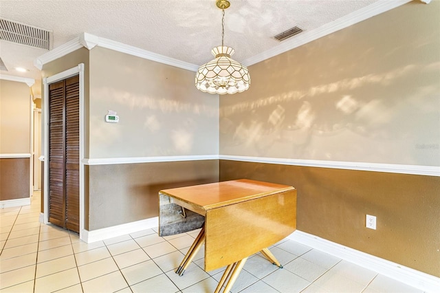 unfurnished dining area with a textured ceiling, light tile patterned floors, and ornamental molding