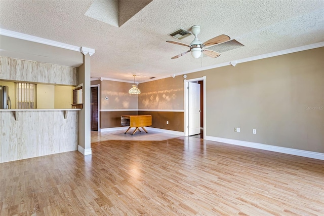 unfurnished living room featuring ceiling fan, light hardwood / wood-style flooring, ornamental molding, and a textured ceiling