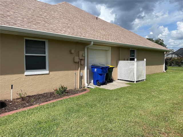 view of side of property with a lawn and a garage