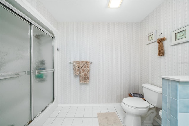 bathroom with toilet, tile patterned floors, and a shower with door