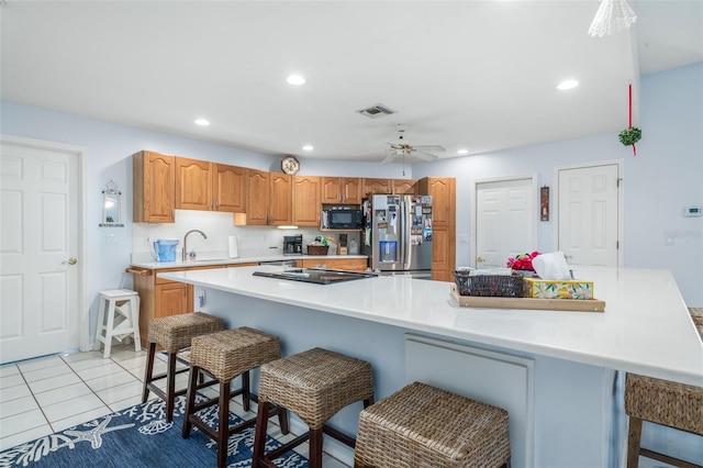 kitchen featuring black appliances, a kitchen island, and a kitchen bar