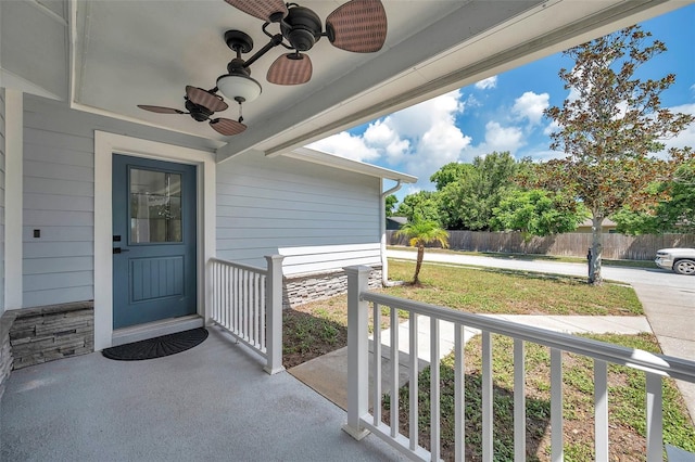 doorway to property featuring ceiling fan and a lawn