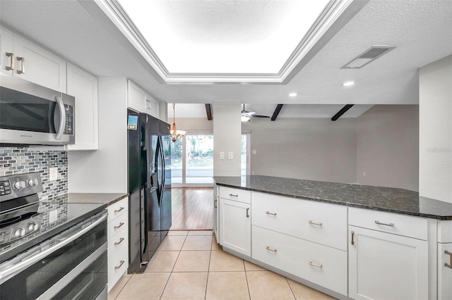 kitchen featuring light tile patterned floors, stainless steel appliances, visible vents, backsplash, and white cabinetry