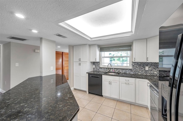 kitchen featuring light tile patterned floors, dark stone countertops, backsplash, black appliances, and white cabinets