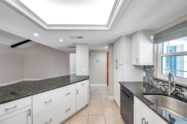 kitchen featuring dark stone counters, dishwasher, light tile patterned floors, tasteful backsplash, and sink