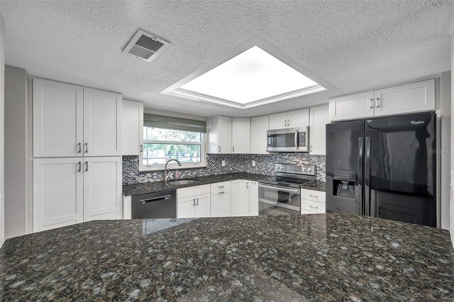 kitchen featuring black appliances, decorative backsplash, and white cabinetry