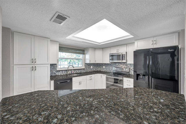 kitchen featuring a sink, visible vents, white cabinets, appliances with stainless steel finishes, and tasteful backsplash