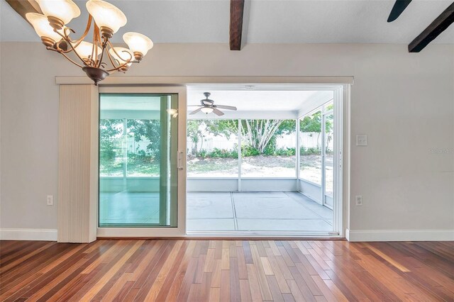 doorway to outside with hardwood / wood-style flooring, ceiling fan with notable chandelier, and beam ceiling