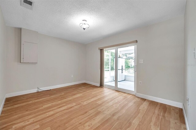 empty room featuring light hardwood / wood-style flooring and a textured ceiling