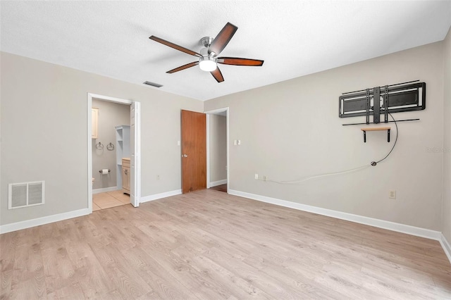 unfurnished bedroom with light wood-style floors, baseboards, visible vents, and a textured ceiling