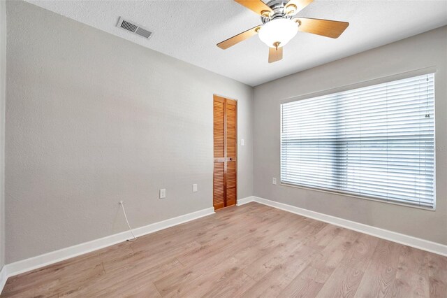 unfurnished room with ceiling fan, a textured ceiling, and light hardwood / wood-style floors