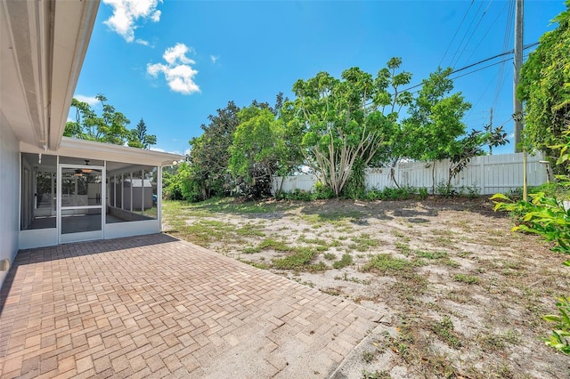 view of yard with a patio, fence, and a sunroom