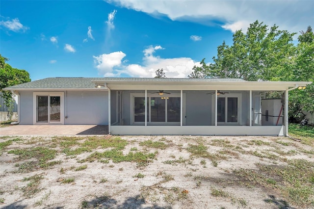 rear view of property featuring ceiling fan, a patio, a sunroom, and stucco siding