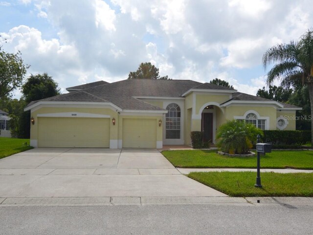 mediterranean / spanish-style home featuring a garage and a front yard