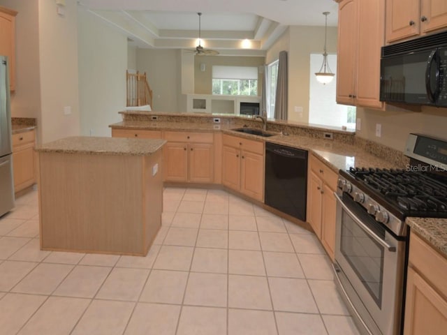 kitchen with a raised ceiling, a center island, light brown cabinetry, and black appliances