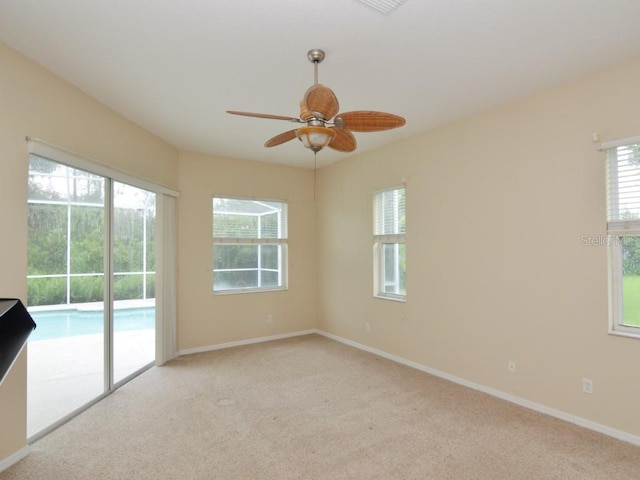 spare room featuring light colored carpet and ceiling fan