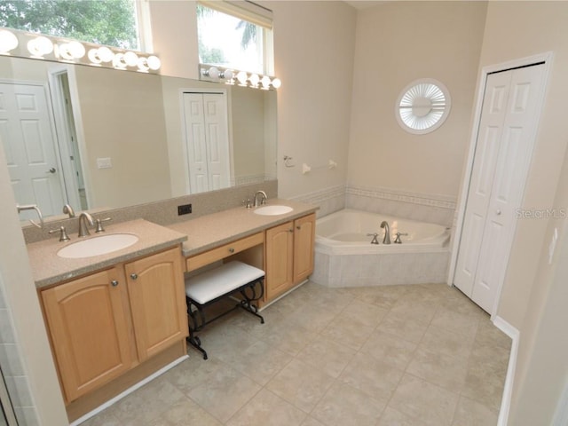 bathroom with vanity, tiled tub, and tile patterned flooring