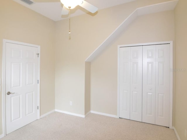 unfurnished bedroom featuring light carpet, ceiling fan, and a closet