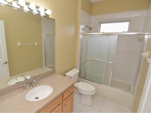 full bathroom featuring toilet, tile patterned floors, vanity, and bath / shower combo with glass door