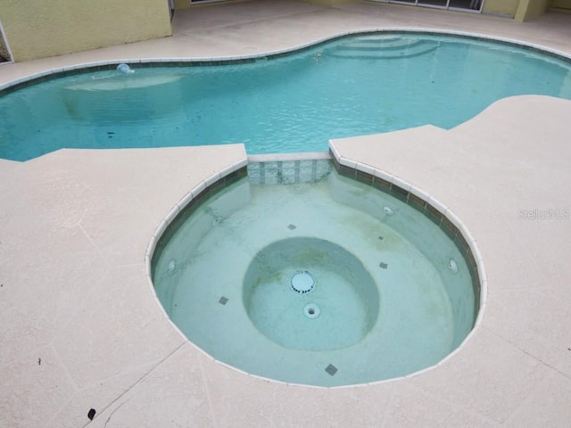 view of pool with an in ground hot tub