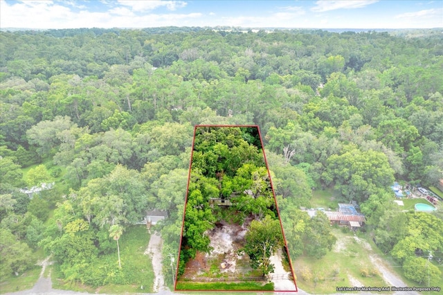 birds eye view of property with a view of trees