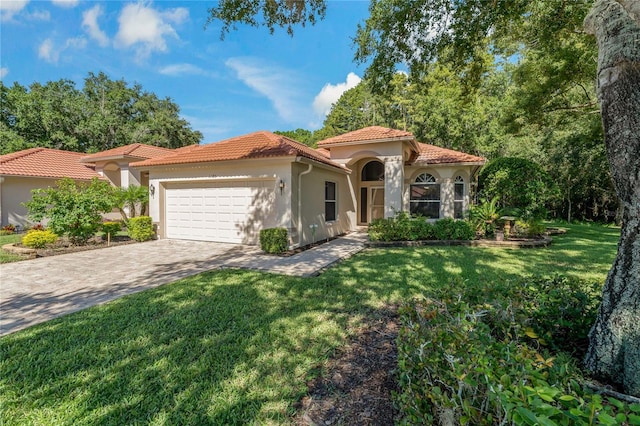 mediterranean / spanish house featuring a garage and a front yard