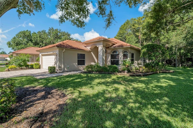 mediterranean / spanish-style home featuring a garage and a front yard