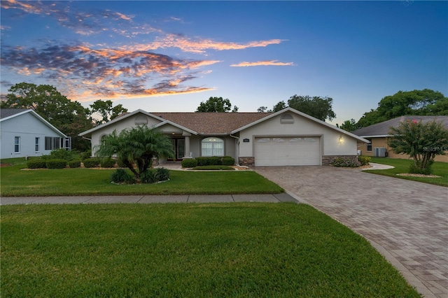 ranch-style home featuring a yard and a garage