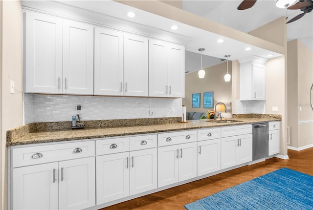 kitchen featuring white cabinetry, stainless steel dishwasher, tasteful backsplash, sink, and wood-type flooring