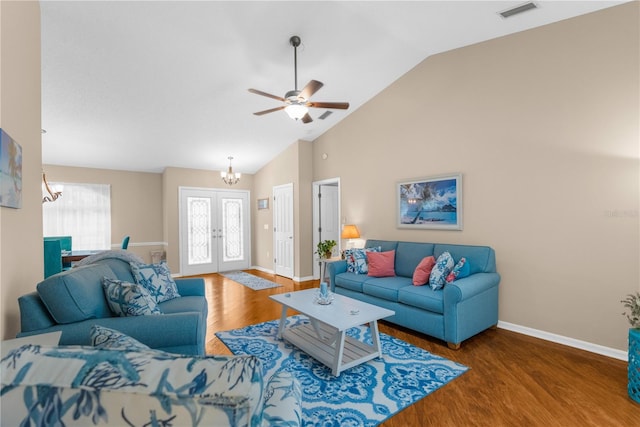 living room with hardwood / wood-style floors, ceiling fan with notable chandelier, and high vaulted ceiling