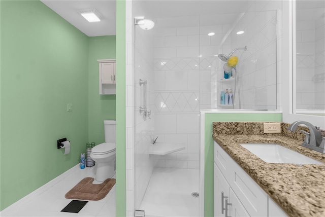 bathroom featuring toilet, a tile shower, vanity, and tile patterned floors