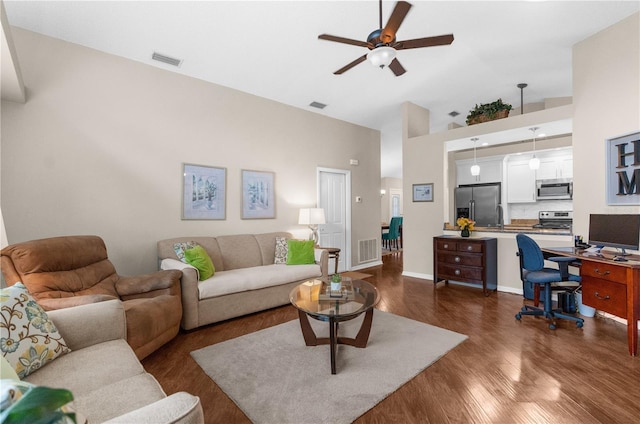 living room with ceiling fan, a high ceiling, and dark hardwood / wood-style flooring