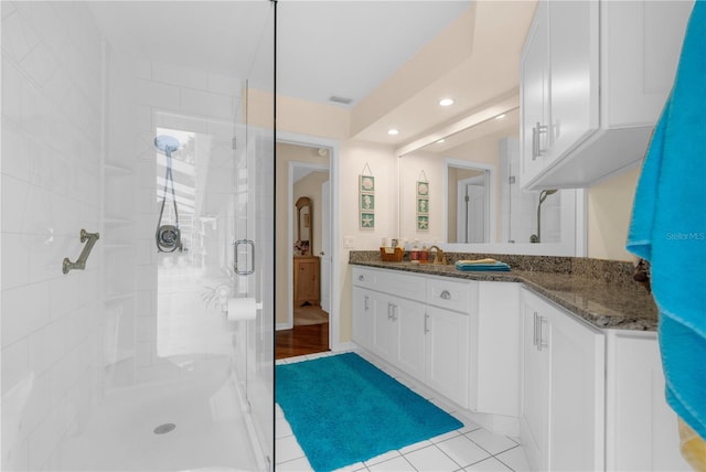 bathroom with a shower with shower door, tile patterned flooring, and vanity