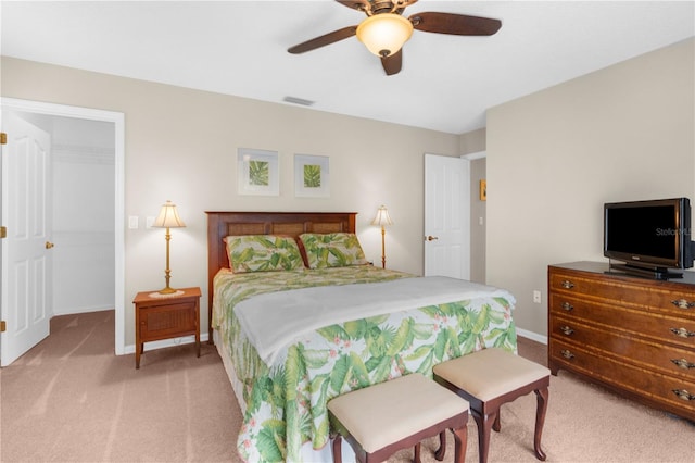 carpeted bedroom featuring ceiling fan, a closet, and a walk in closet