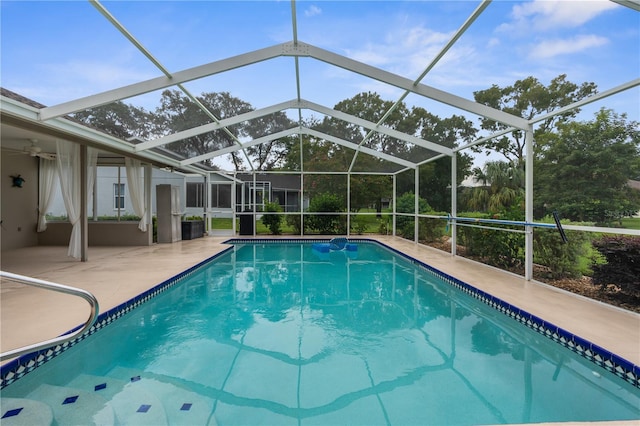 view of swimming pool featuring glass enclosure and a patio