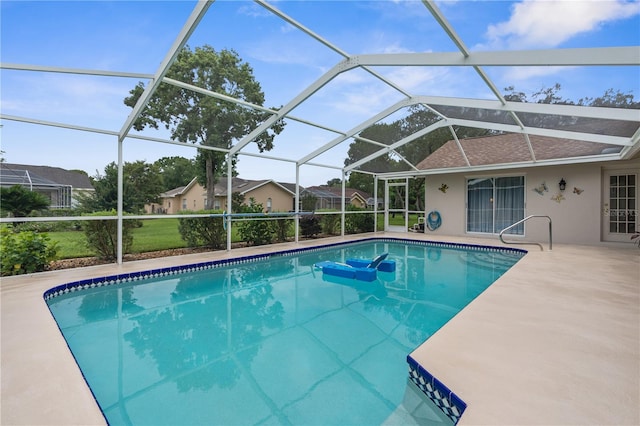 view of swimming pool with glass enclosure and a patio