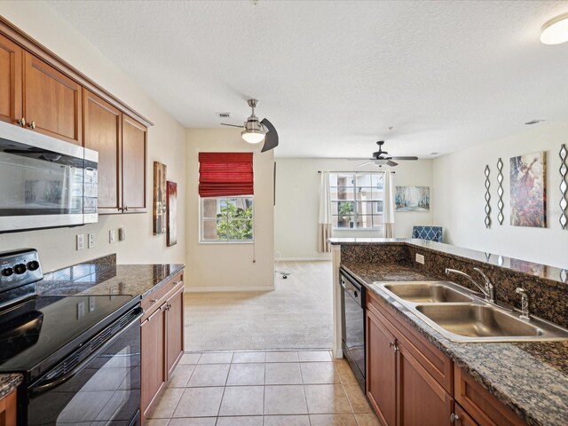 kitchen featuring black range with electric cooktop, light tile patterned floors, dishwasher, sink, and ceiling fan