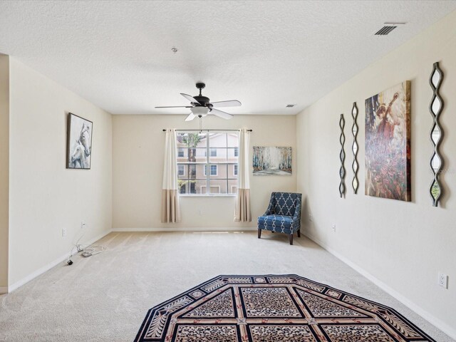 unfurnished room featuring ceiling fan, a textured ceiling, and carpet floors