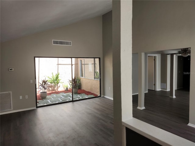 interior space with dark wood-style floors, high vaulted ceiling, visible vents, and baseboards