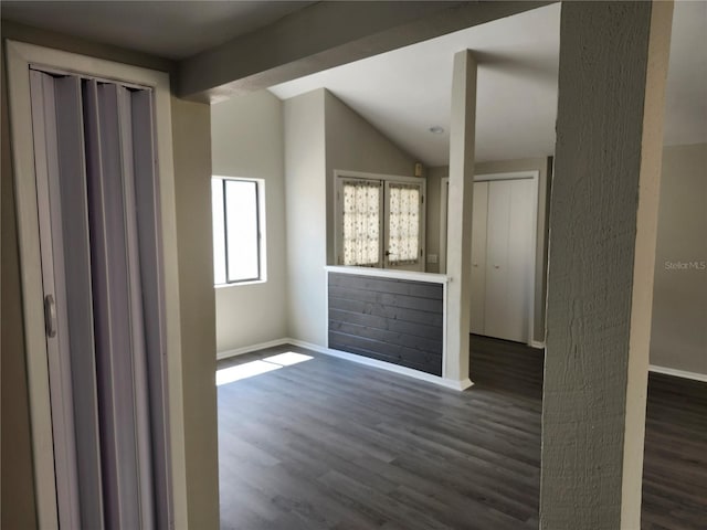 empty room with lofted ceiling and dark wood-type flooring