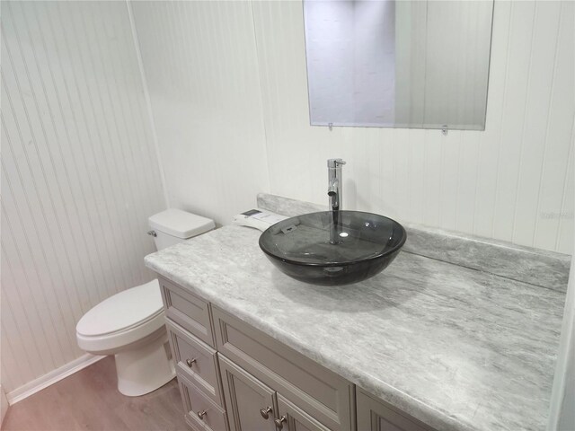 bathroom with wood-type flooring, toilet, and vanity