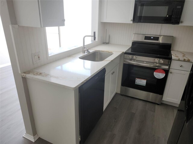 kitchen featuring sink, dark wood-type flooring, light stone countertops, stainless steel electric range, and white cabinets