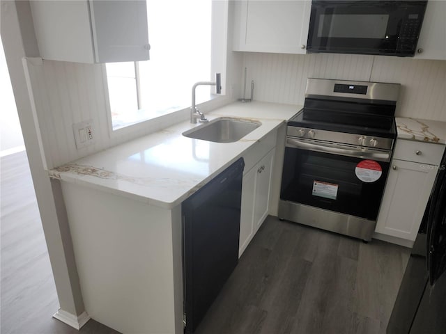 kitchen featuring light stone counters, white cabinets, a sink, wood finished floors, and black appliances