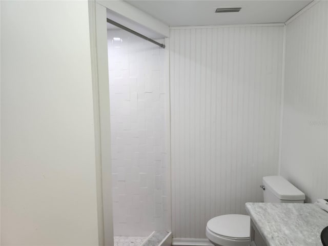 full bathroom featuring toilet, visible vents, a tile shower, and vanity