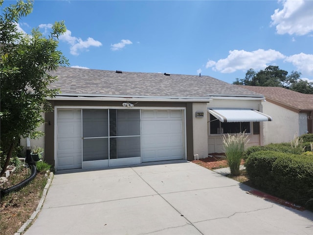 ranch-style house with concrete driveway, roof with shingles, an attached garage, and stucco siding