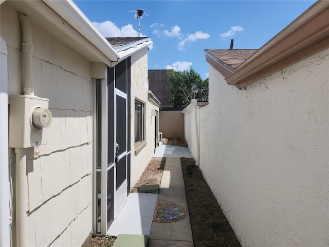 view of property exterior featuring roof with shingles and fence