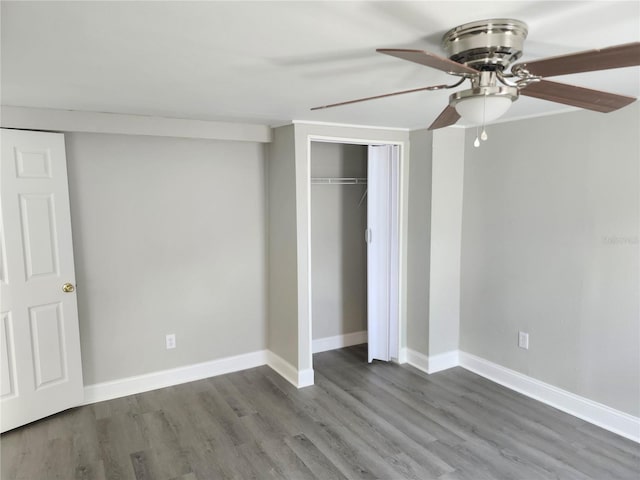 unfurnished bedroom with a closet, ceiling fan, baseboards, and wood finished floors