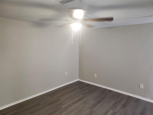 unfurnished room featuring a ceiling fan, baseboards, visible vents, and dark wood-style flooring